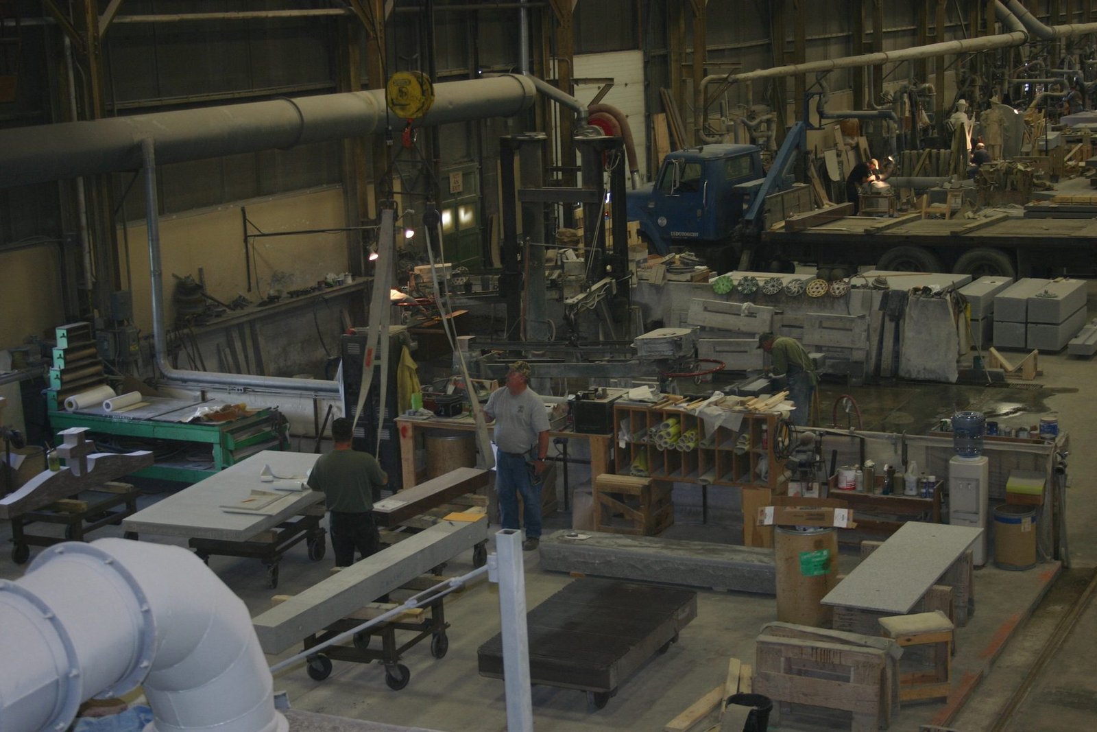 The floor of a large stone finishing shed with benches, carts and slabs